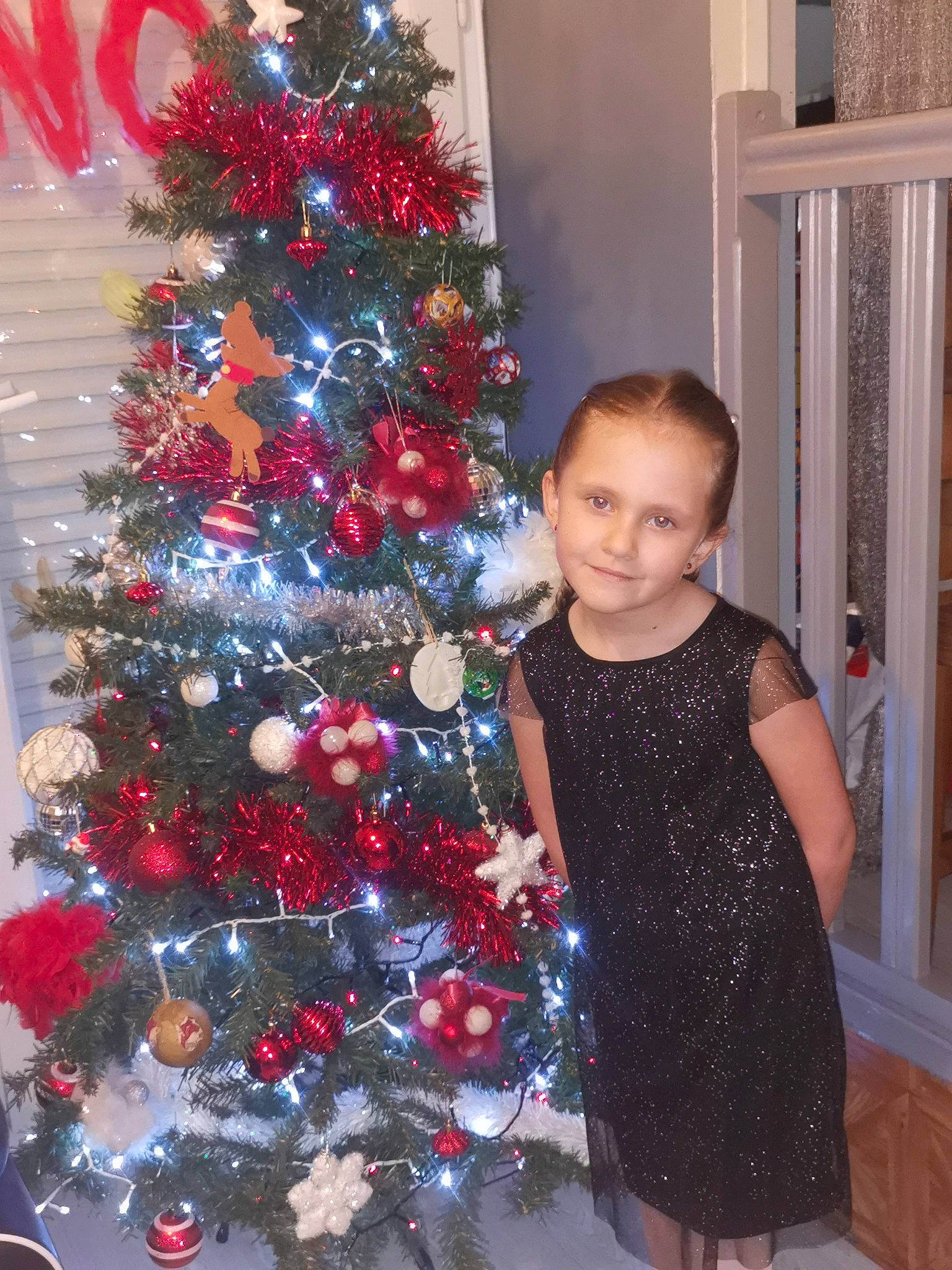 éléana a rejoint le concours — aidez-le/la à gagner de superbes lots ! baby_toddler_clothing, beauty, black, christmas_decoration, christmas_ornament, christmas_tree, event, evergreen, holiday_ornament, human_body, joy, ornament, person, photograph, plant, red, smile, snapshot, standing, tree