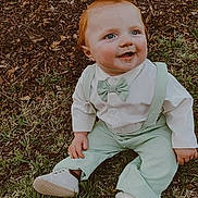 Zayden is registered to the contest to win money with this photo: baby, child, grass, tree, outdoor, smiling, happy, blue_eyes, red_hair, suspenders, bow_tie, white_shoes, cute, nature, fall_leaves, sitting, portrait, young_child, casual_clothing, daylight