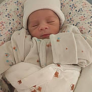 Malo participe au concours pour gagner de l'argent avec cette photo : newborn, baby, sleeping, hat, pajamas, blanket, cushion, pattern, floral, indoors, closeup, infant, cozy, swaddled, soft, person, child, cute, peaceful, resting