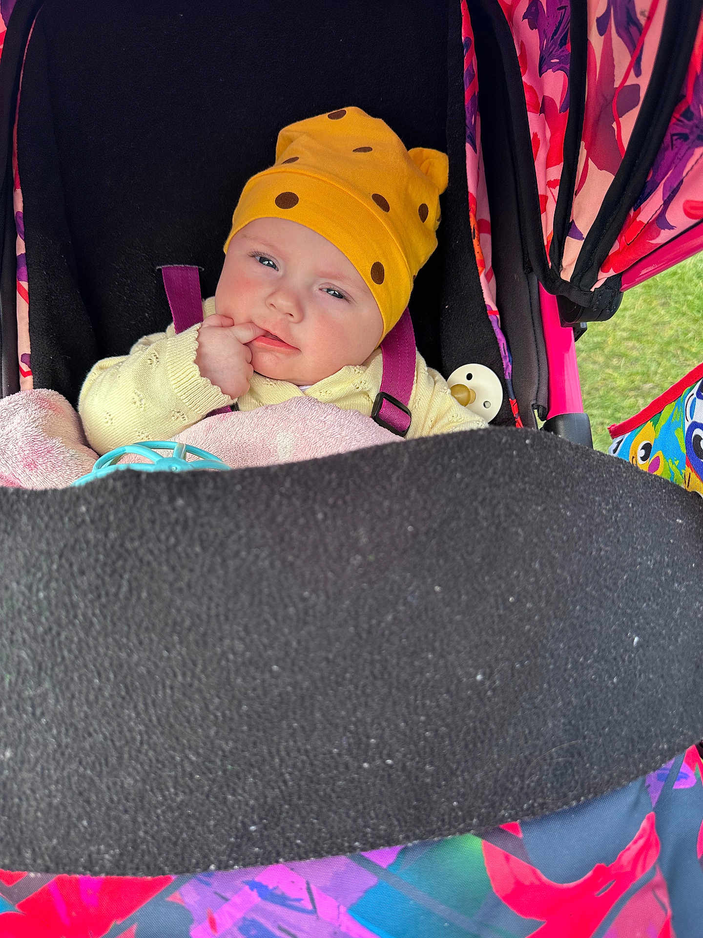 Eva joined the competition — help win amazing prizes! baby, stroller, yellow_hat, blanket, pacifier, child, infant, colorful, outdoor, clothing, face, hand, seatbelt, toy, person, portrait, cute, expression, warm_clothing, resting
