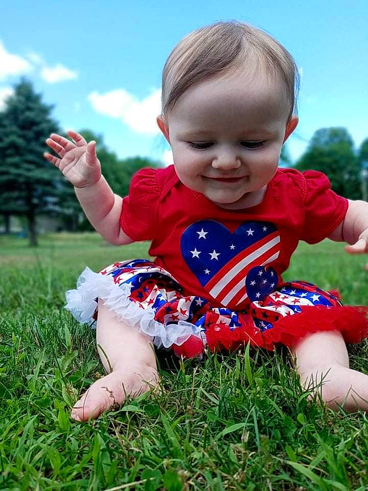 Kendall is registered to the contest to win money with this photo: baby_toddler_clothing, child, cloud, facial_expression, finger, fun, gesture, grass, grassland, happy, joy, leisure, pattern, people_in_nature, person, plant, recreation, sky, sleeve, t_shirt