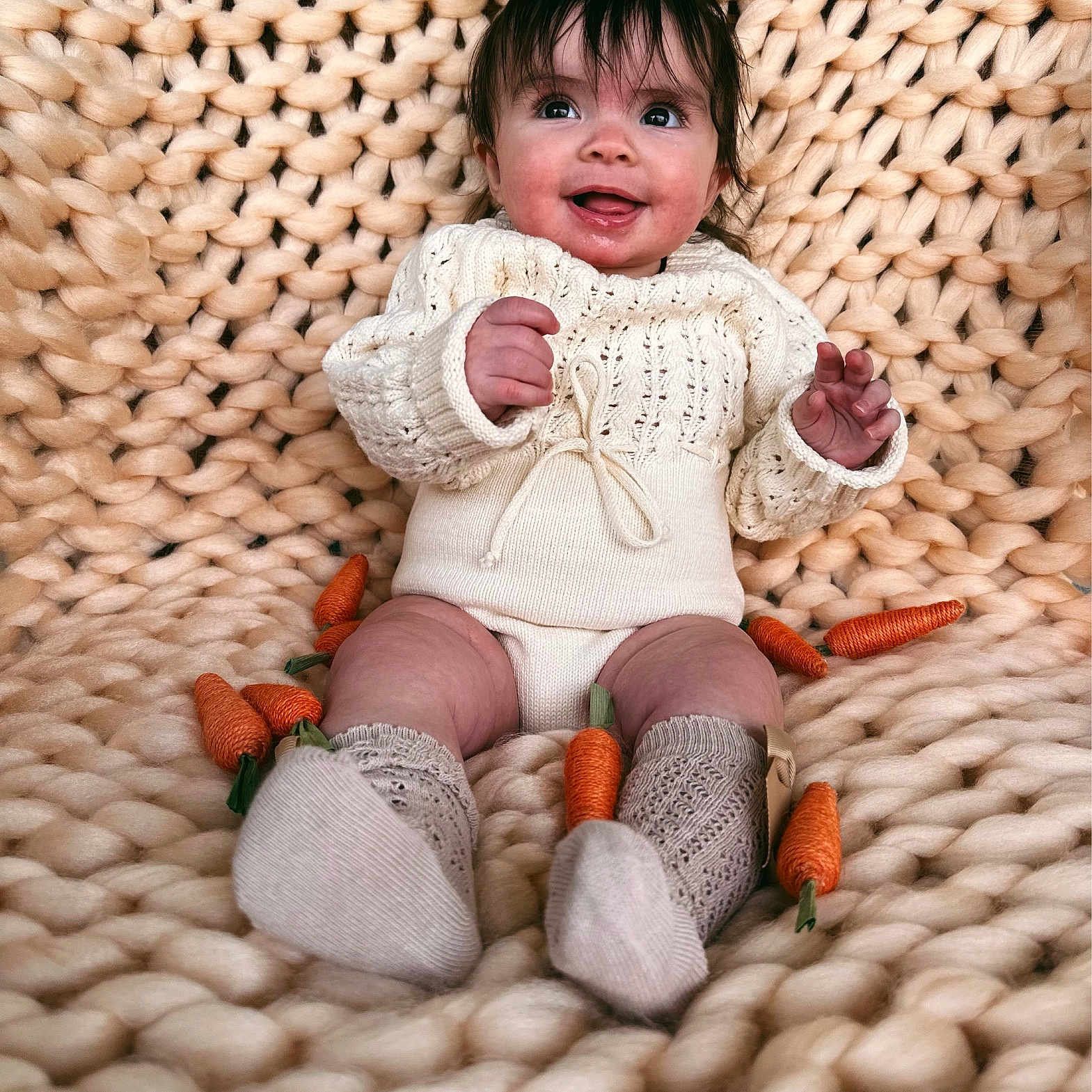 Alessia is registered to the contest to win money with this photo: baby, bodypart, carrot, clothing, face, finger, food, hand, happy, head, hosiery, knitwear, person, photography, plant, portrait, produce, sitting, sock, sweater
