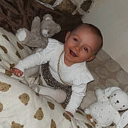 Kym participe au concours pour gagner de l'argent avec cette photo : baby, bed, blanket, child, cozy, cushion, cute, gold_chain, happy, home, indoor, infant, playful, portrait, smiling, soft_toys, stone_wall, stuffed_animal, teddy_bear, white_clothing