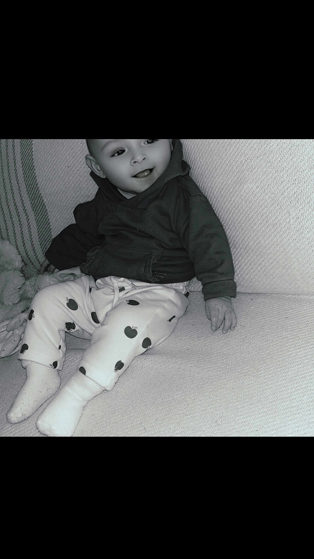 Kym a rejoint le concours — aidez-le/la à gagner de superbes lots ! baby, child, smiling, hoodie, pants, apple_pattern, socks, couch, indoor, person, portrait, happy, seated, cozy, cute, infant, clothing, face, hand, texture