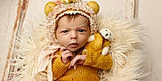Addison is registered to the contest to win money with this photo: baby, infant, teddy_bear, knitwear, yellow_clothing, bonnet, floral, bear_ears, blanket, fur_texture, wooden_floor, cute, portrait, child, newborn, soft_lighting, indoors, expression, hand_position, cozy