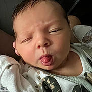Addison is registered to the contest to win money with this photo: baby, child, closeup, clothing, cute, expression, face, funny_face, hand, head, infant, mouth, newborn, onesie, person, portrait, skin, sleepy, tongue, tongue_out