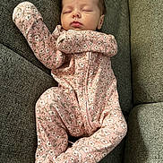 Addison joined the competition — help win amazing prizes! baby, sleeping, infant, onesie, pink, floral_pattern, couch, gray, cozy, peaceful, child, face, comfort, rest, indoors, young, cute, portrait, soft, relax