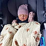 baby, car_seat, blanket, pink_hat, mittens, sleeping, infant, child, graco, protectplus, cozy, soft_texture, patterned_blanket, resting, cute, wrapped_up, indoor, seatbelt, headrest, peaceful