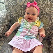 Elaya is registered to the contest to win money with this photo: baby, child, smile, headband, pink, dress, patterned_chair, indoor, happy, cute, infant, sitting, colorful_clothing, portrait, face, armchair, young_child, cheerful, headwear, baby_girl