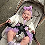 Elaya is registered to the contest to win money with this photo: baby, stroller, purple, headband, bow, smile, happy, socks, jacket, outdoor, pavement, child, cute, infant, toddler, person, seatbelt, accessory, walking, casual