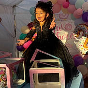 Manraj Kaur is registered to the contest to win money with this photo: child, girl, black_dress, balloons, birthday_party, number_2_balloon, gift_boxes, table, tent, smiling, happy, celebration, curly_hair, bow, colorful, party_decorations, indoors, person, young, festive