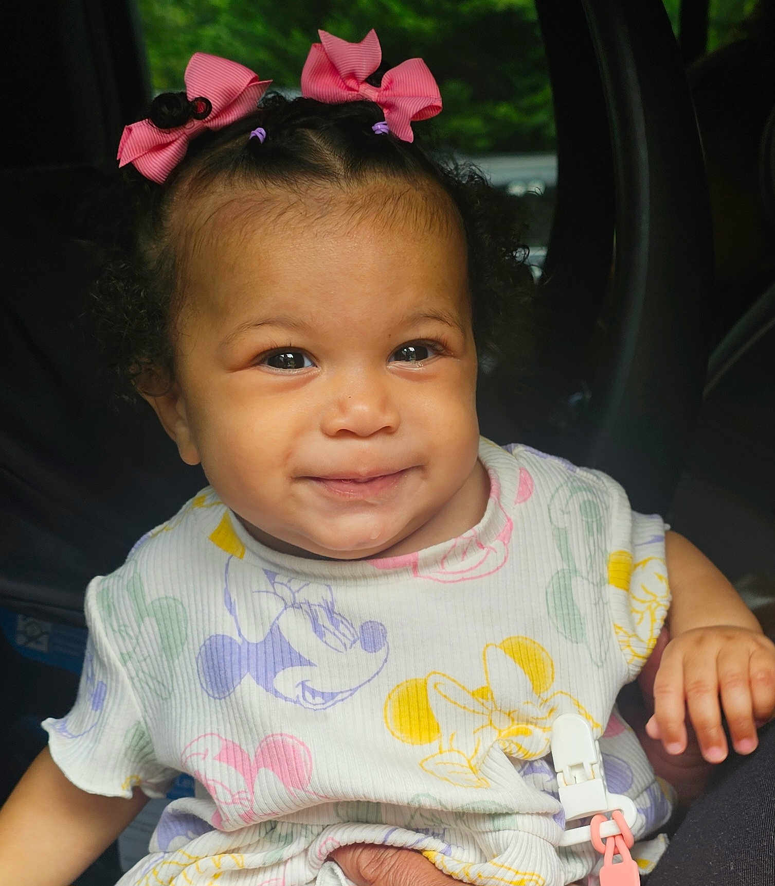 Adahra is registered to the contest to win money with this photo: baby, child, clothing_pattern, colorful_clothing, curly_hair, cute, cute_baby, face, hand, happy, indoors, infant, mickey_mouse, natural_light, person, pink_bow, portrait, sitting, smile, toddler