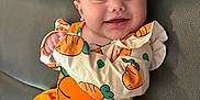 Marymae joined the competition — help win amazing prizes! baby, child, smiling, cute, carrot_outfit, headband, orange, yellow, dress, leather_couch, happy, infant, portrait, clothing, sitting, young_child, indoors, face, person, adorable