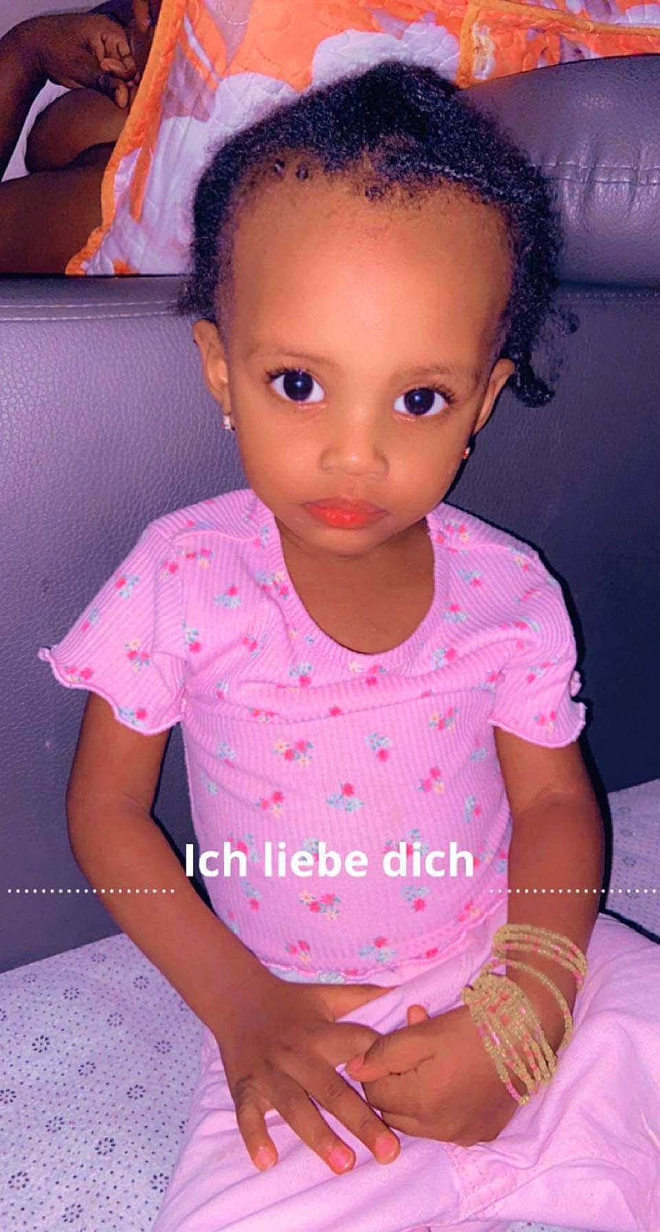 Hadja Oumou a rejoint le concours — aidez-le/la à gagner de superbes lots ! baby_toddler_clothing, black_hair, cheek, chin, dress, eyebrow, eyelash, forehead, hair, hand, iris, joint, lip, magenta, mouth, nose, person, pink, purple, skin