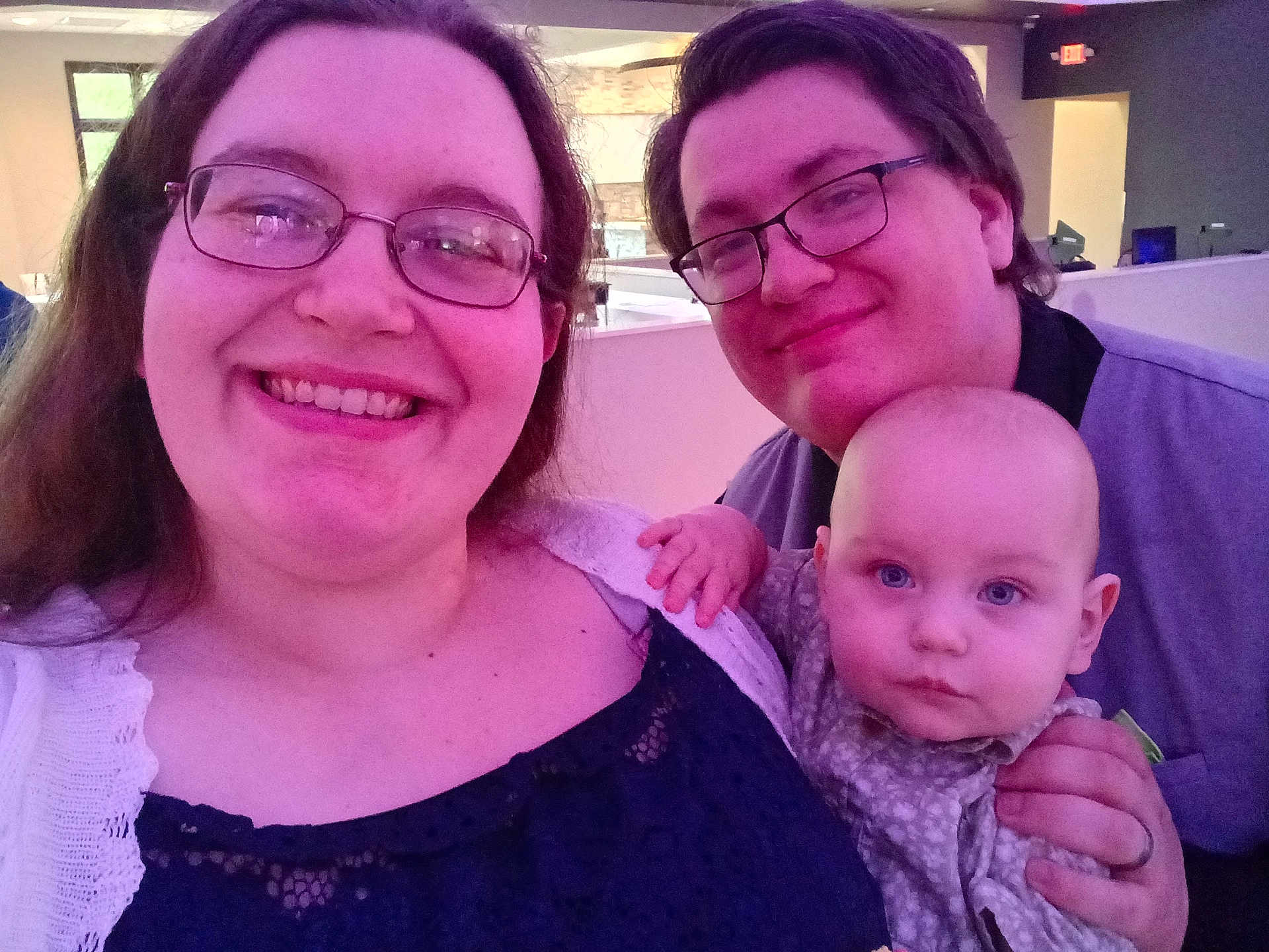 Devlin is registered to the contest to win money with this photo: family, selfie, baby, adult, glasses, smile, indoor, purple_lighting, person, face, clothing, hand, curious, happy, together, portrait, candid, people, head, casual