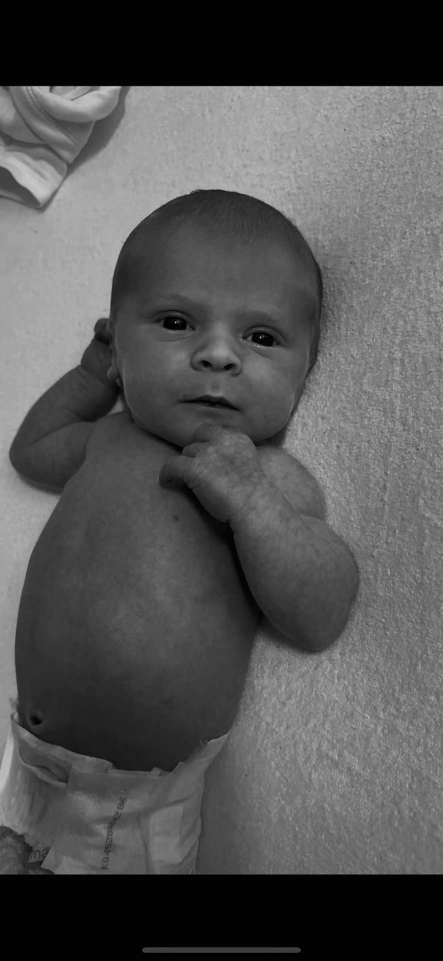 Frankie-Junior is registered to the contest to win money with this photo: baby, newborn, infant, diaper, black_and_white, lying_down, curious, face, hand, skin, portrait, closeup, expression, child, human, small, cute, texture, monochrome, soft