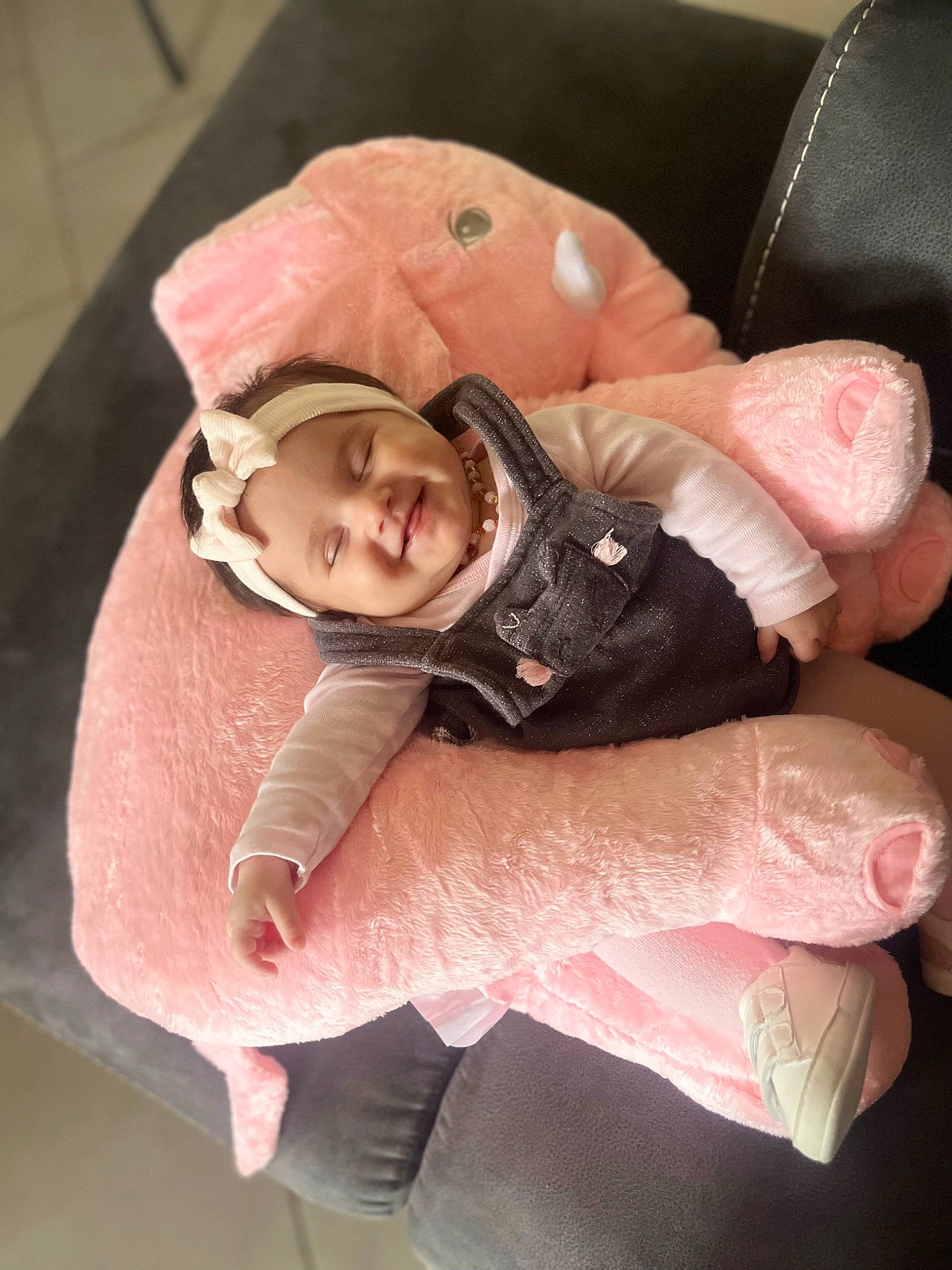 Emy participe au concours pour gagner de l'argent avec cette photo : child, comfort, eye, face, fashion_accessory, finger, fur, gesture, happy, headwear, human_body, human_leg, joy, knee, linens, person, personal_protective_equipment, pink, sitting, smile