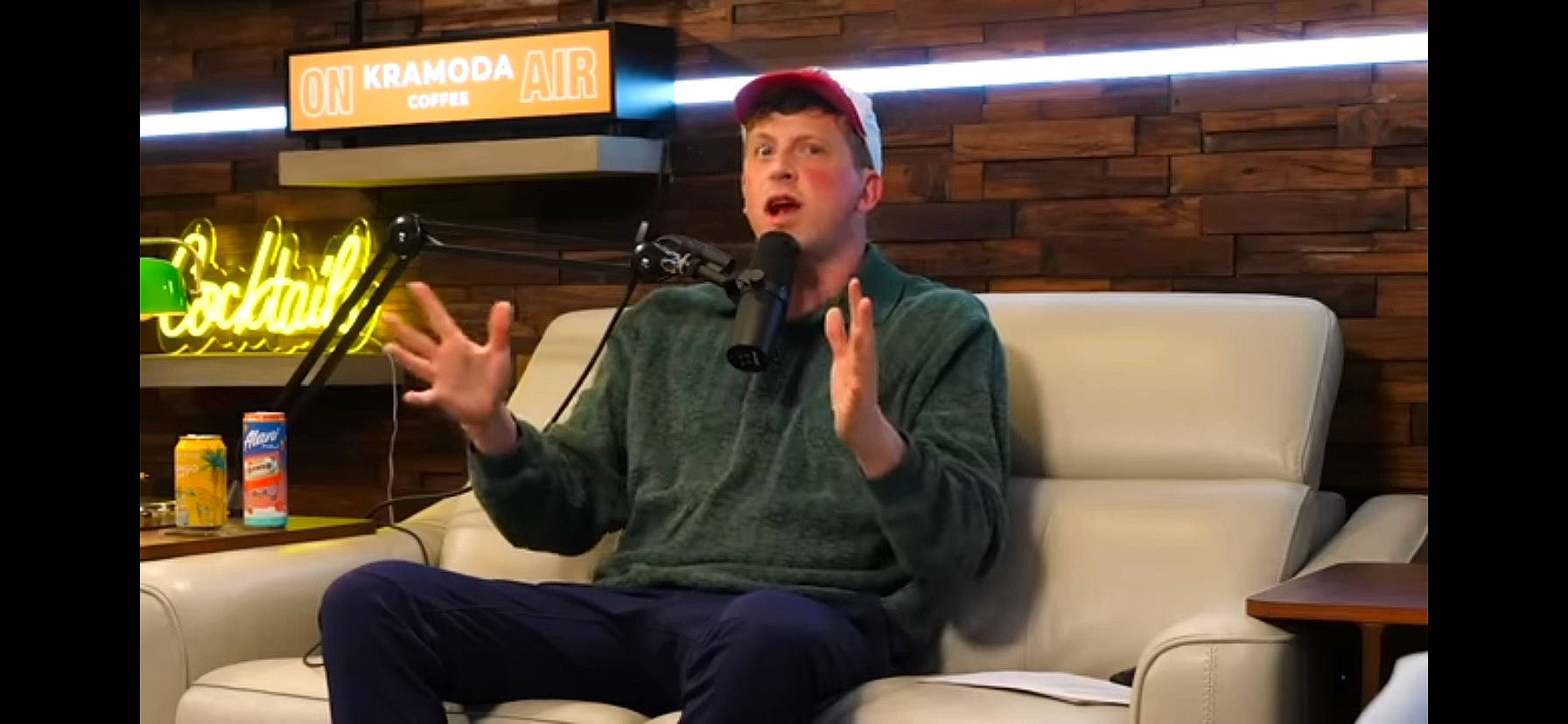 Hunter is registered to the contest to win money with this photo: audio_equipment, chair, comfort, conversation, entertainment, event, fun, furniture, headwear, leisure, logo, media, microphone, person, room, sitting, speech, spokesperson, surprise, t_shirt