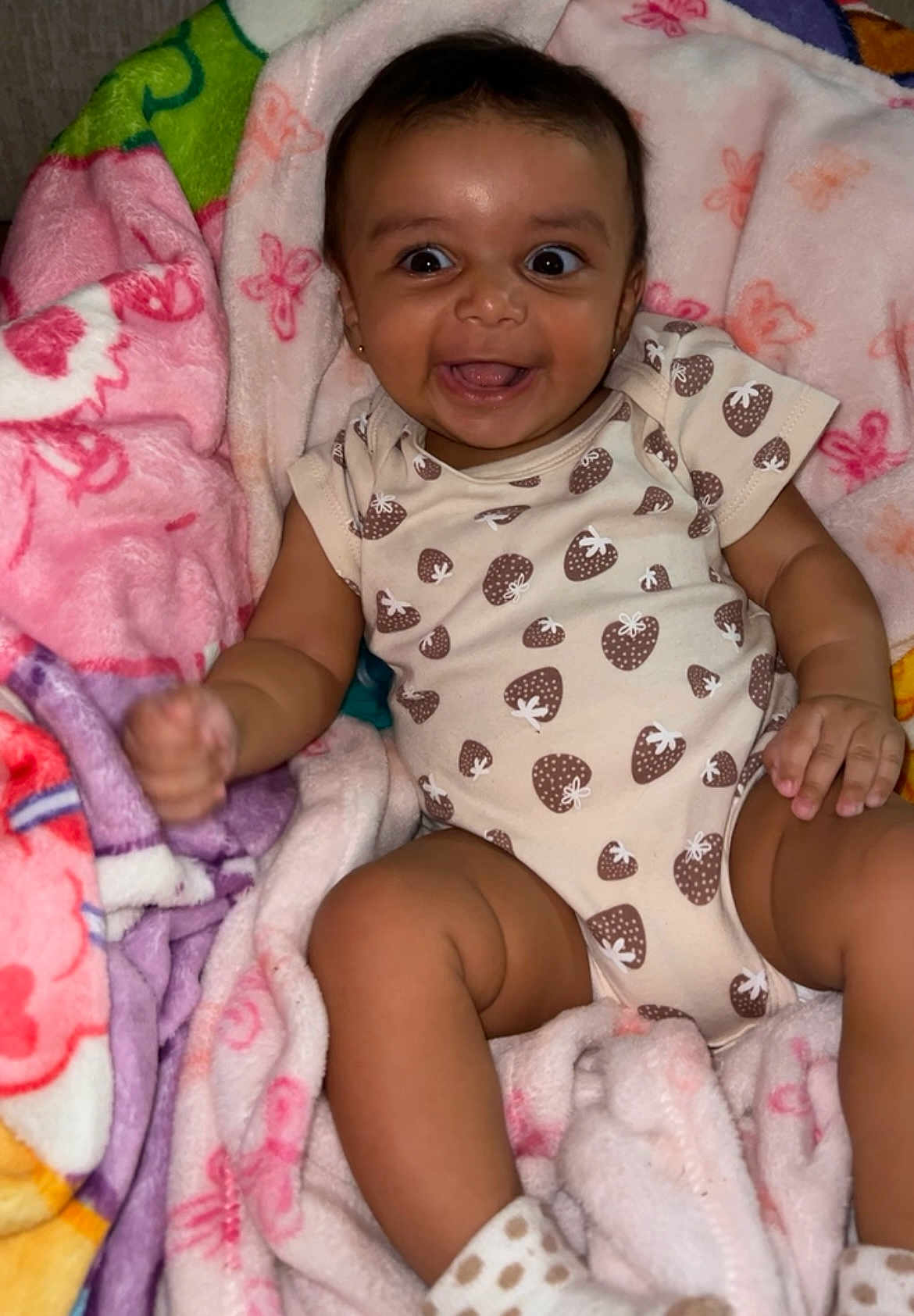 Leila joined the competition — help win amazing prizes! baby, blanket, child, colorful, cozy, cute, face, hand, happy, indoors, infant, onesie, pattern, polka_dot, portrait, skin, smiling, socks, soft, strawberry