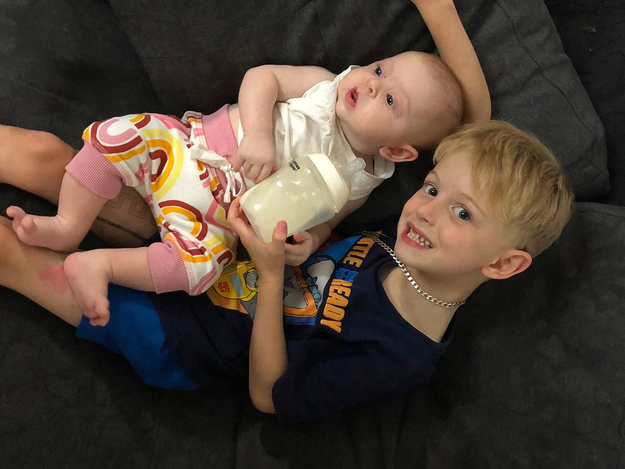 Colton is registered to the contest to win money with this photo: baby, baby_toddler_clothing, barefoot, cheek, child, comfort, event, flash_photography, foot, fun, happy, human_leg, joy, knee, person, portrait_photography, sibling, sitting, skin, smile