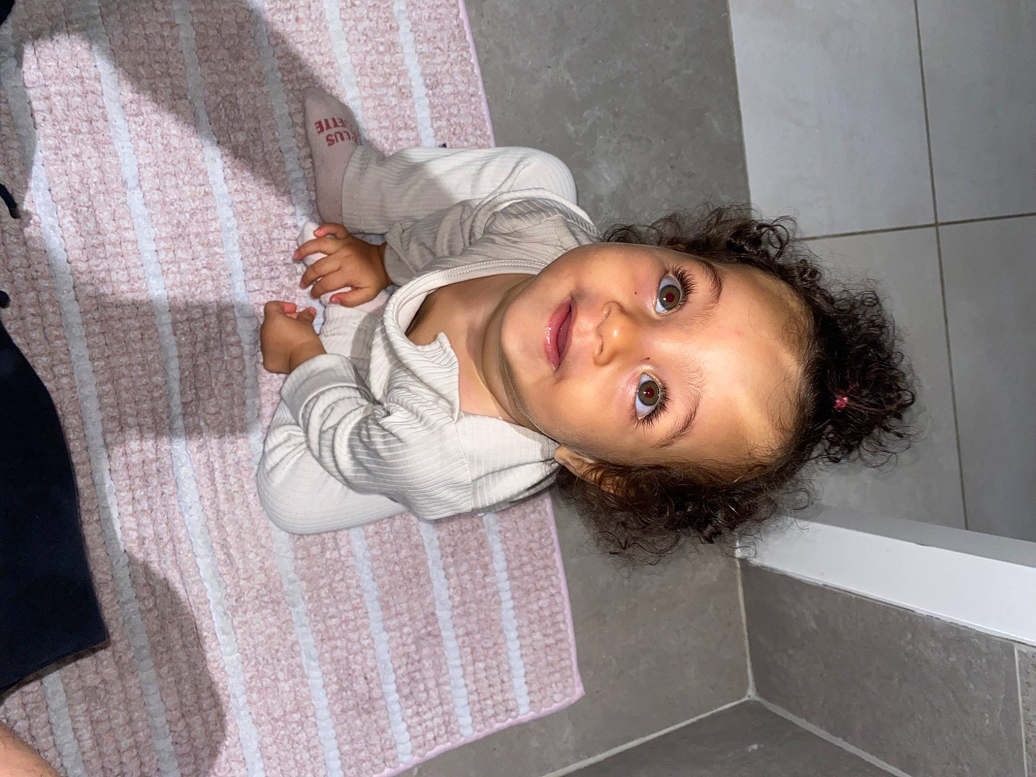 Jade participe au concours pour gagner de l'argent avec cette photo : baby_toddler_clothing, cheek, child, comfort, flooring, fun, hair, happy, head, linens, lip, nose, pattern, person, room, sitting, skin, smile, toddler