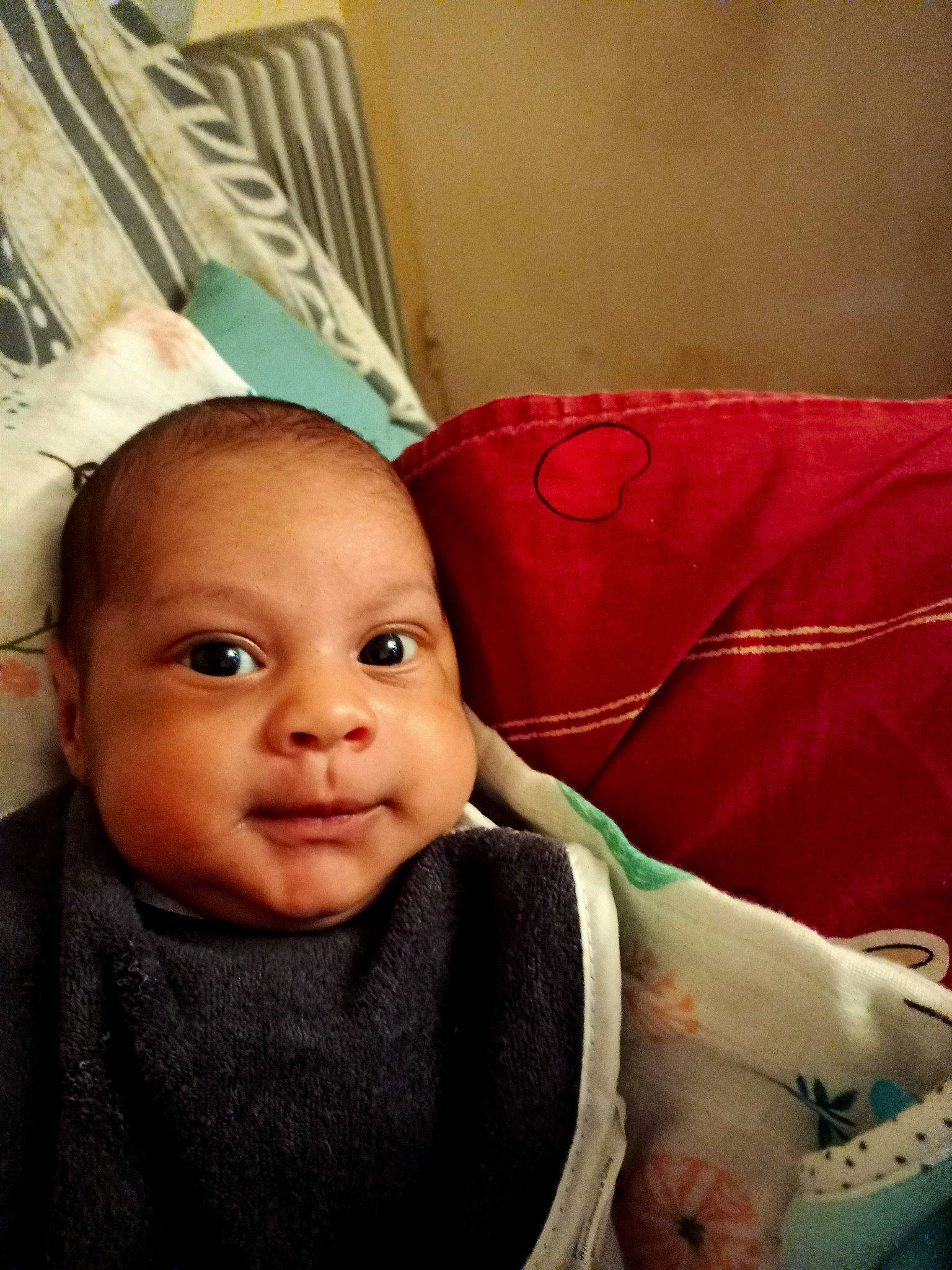 Ismaël participe au concours pour gagner de l'argent avec cette photo : baby, baby_toddler_clothing, cheek, child, chin, comfort, eye, eyebrow, eyelash, happy, head, linens, lip, mouth, nose, person, sitting, skin, sleeve, smile