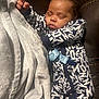 baby, sleeping, blanket, clothing, infant, pattern, blue, white, face, hand, leather, couch, nap, peaceful, cozy, soft, portrait, indoor, child, resting