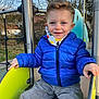 Alessio a rejoint le concours — aidez-le/la à gagner de superbes lots ! child, toddler, blue_jacket, slide, playground, outdoor, smiling, happy, winter_clothing, park, metal_pole, trees, daylight, face, person, casual_clothing, fun, young_child, scarf, play