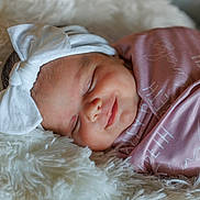 Kinsley joined the competition — help win amazing prizes! baby, newborn, sleeping, headband, bow, pink_blanket, fluffy, soft_texture, closeup, face, peaceful, infant, cute, wrapped, portrait, resting, cozy, child, adorable, sleep