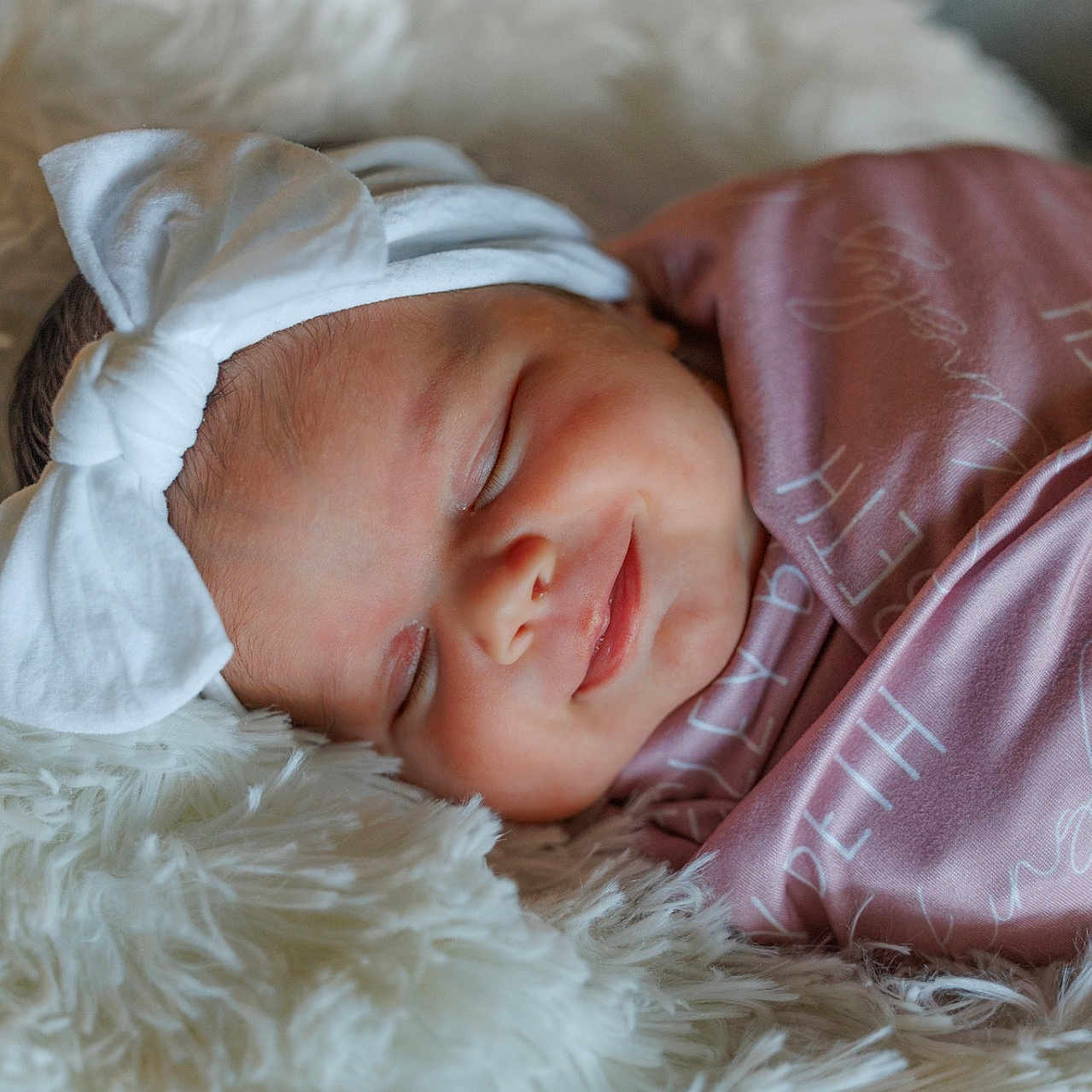 Kinsley joined the competition — help win amazing prizes! baby, newborn, sleeping, headband, bow, pink_blanket, fluffy, soft_texture, closeup, face, peaceful, infant, cute, wrapped, portrait, resting, cozy, child, adorable, sleep