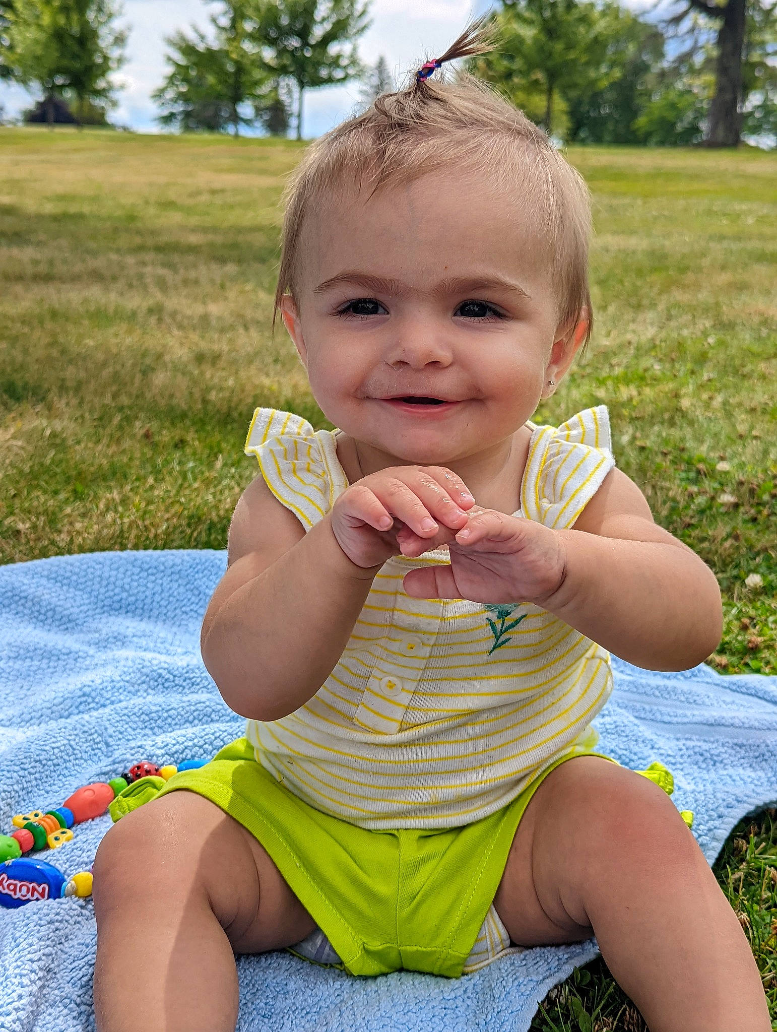 Charly is registered to the contest to win money with this photo: baby_toddler_clothing, cheek, face, facial_expression, finger, fun, grass, happy, head, iris, joy, leaf, leisure, people_in_nature, person, pink, plant, skin, sky, smile