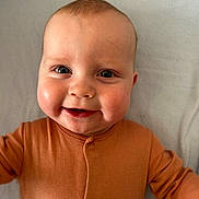 Harry joined the competition — help win amazing prizes! baby, child, smiling, face, cheeks, orange_clothing, infant, lying_down, closeup, happy, cute, skin, eyes, buttoned_outfit, indoors, portrait, young_child, head, soft_texture, blanket