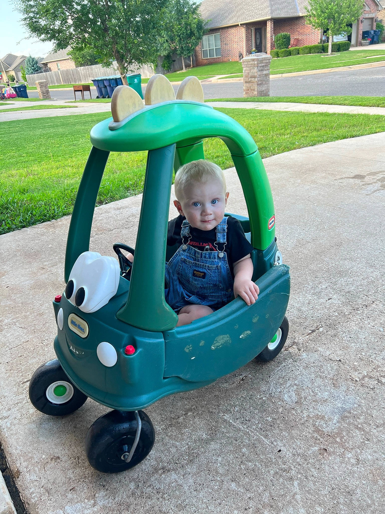Koen joined the competition — help win amazing prizes! baby, baby_products, baby_toddler_clothing, building, child, fun, grass, green, leisure, motor_vehicle, person, plant, recreation, riding_toy, sitting, sky, tire, toddler, tree, vehicle