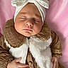 Alya a rejoint le concours — aidez-le/la à gagner de superbes lots ! baby, sleeping, infant, headband, white_bow, brown_clothing, fur_vest, pink_blanket, hand, face, peaceful, portrait, closeup, soft_lighting, cute, child, newborn, resting, cozy, indoor
