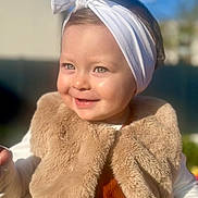 Elena participe au concours pour gagner de l'argent avec cette photo : toddler, child, smile, headband, white, vest, fuzzy, outdoor, sunlight, portrait, happy, baby, cute, face, clothing, headwear, person, warm, daylight, blurred_background