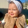 toddler, child, smile, headband, white, vest, fuzzy, outdoor, sunlight, portrait, happy, baby, cute, face, clothing, headwear, person, warm, daylight, blurred_background