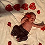 baby, infant, blanket, red_rose, heart_decor, plush_toy, soft_texture, sleeping, cute, adorable, child, newborn, clothing, pants, toy, laying_down, peaceful, indoor, decor, portrait