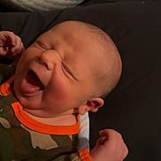 Dawson joined the competition — help win amazing prizes! baby, infant, camo_clothing, orange_trim, sleepwear, face, mouth_open, closed_eyes, hand, blanket, bottle, soft_surface, indoor, newborn, cute, expression, lying_down, skin, head, person