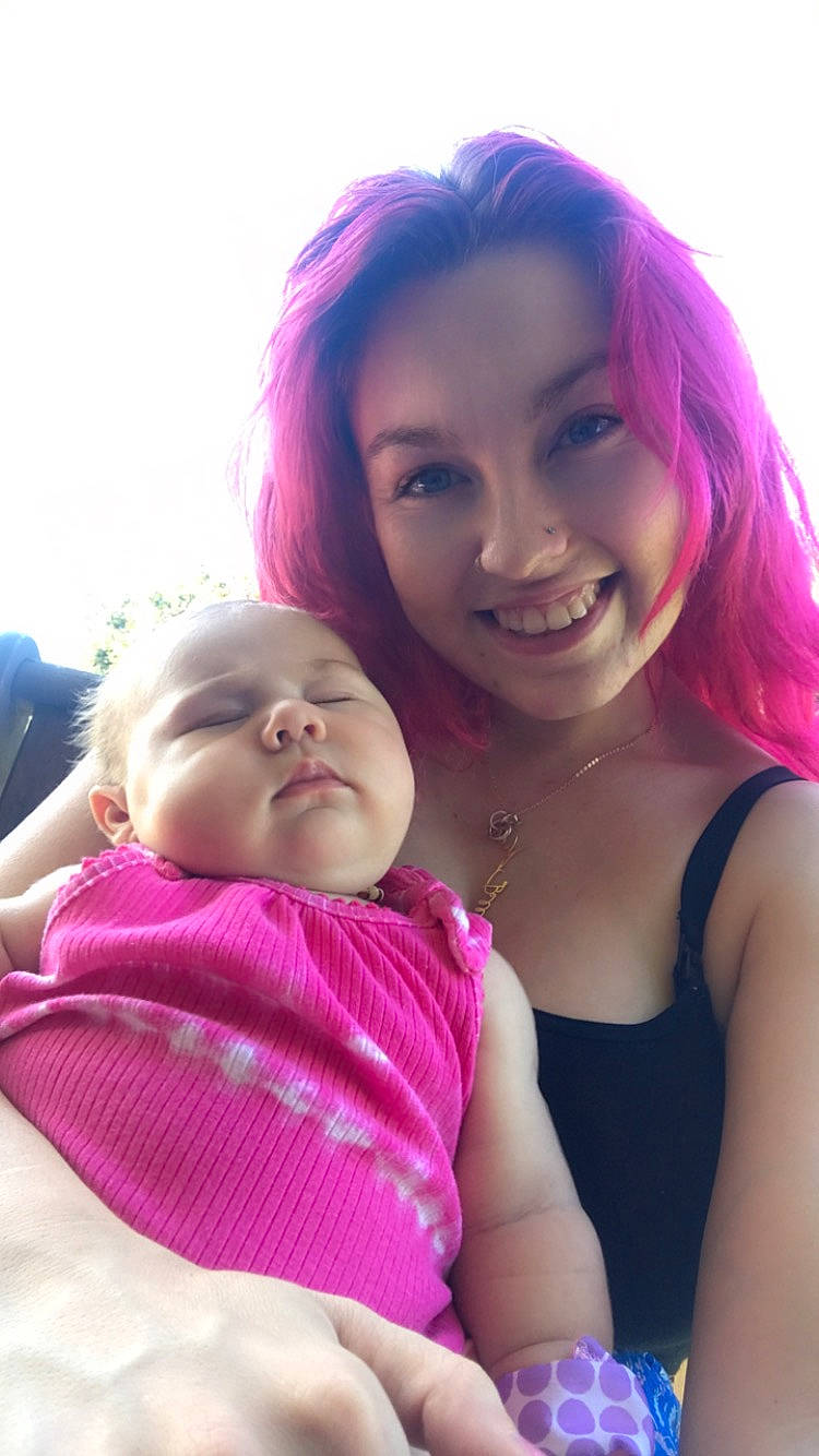 Davina is registered to the contest to win money with this photo: abdomen, baby, bangs, chest, chin, fun, gesture, grass, happy, joy, leisure, lip, magenta, mouth, person, pink, portrait_photography, shoulder, sitting, skin