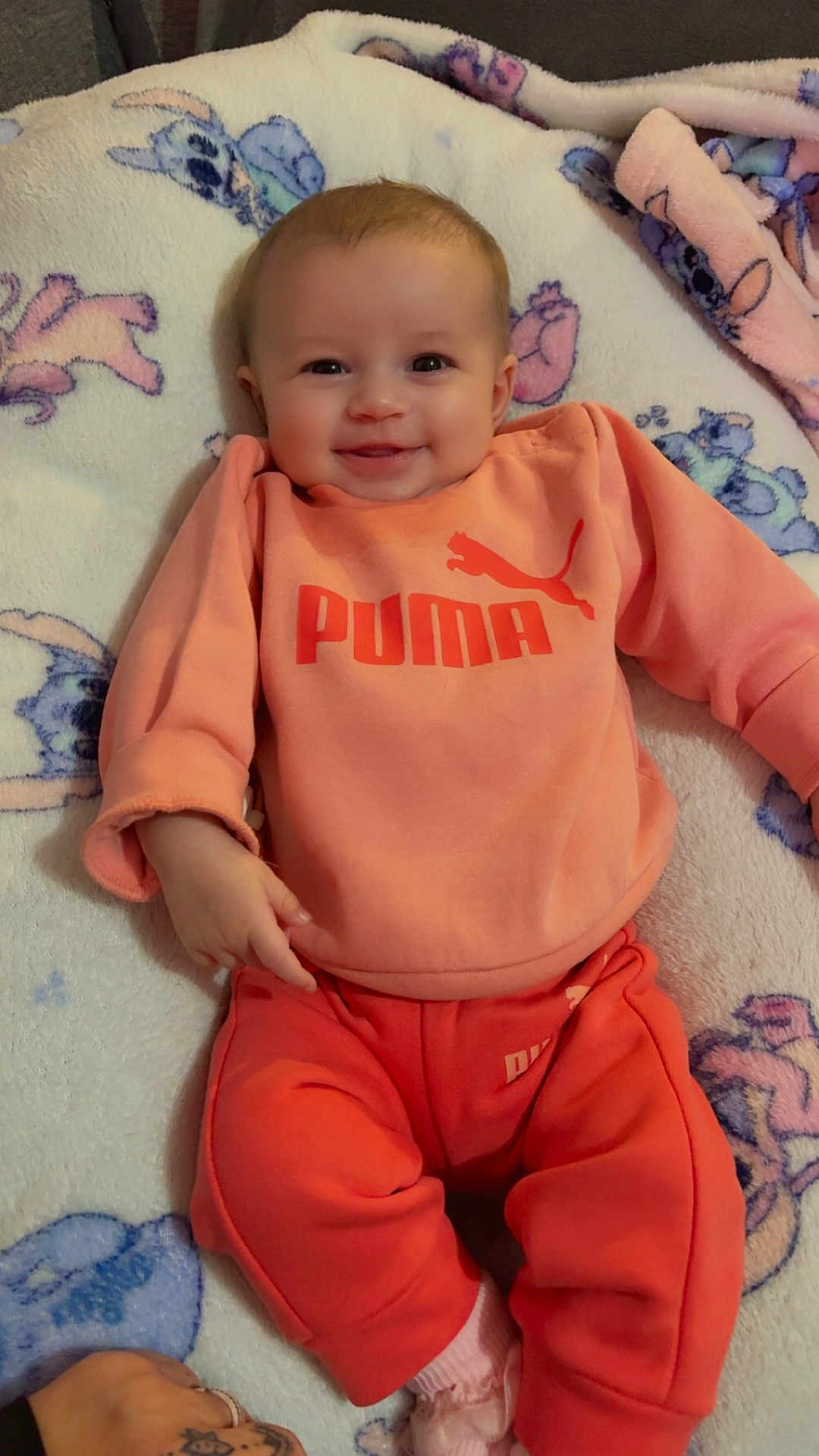 Giulia a rejoint le concours — aidez-le/la à gagner de superbes lots ! baby, smiling, infant, orange_clothing, puma_logo, blanket, soft_texture, cute, happy, child, portrait, indoor, sitting, cozy, warm_clothing, face, person, fashion, casual, comfort