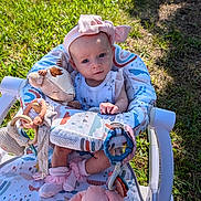 Bonnie is registered to the contest to win money with this photo: baby, infant, child, outdoor, grass, stroller, seat, portrait, smiling, face, pink_hat, bow, clothing, stuffed_animal, giraffe_toy, bunny_toy, baby_toys, blanket, sunlight, playtime