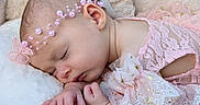 Bonnie is registered to the contest to win money with this photo: baby, blanket, butterfly_bow, child, close_up, face, fluffy, hands, headband, indoor, infant, lace, newborn, peaceful, pearls, photography, pink_dress, portrait, sleeping, soft_lighting