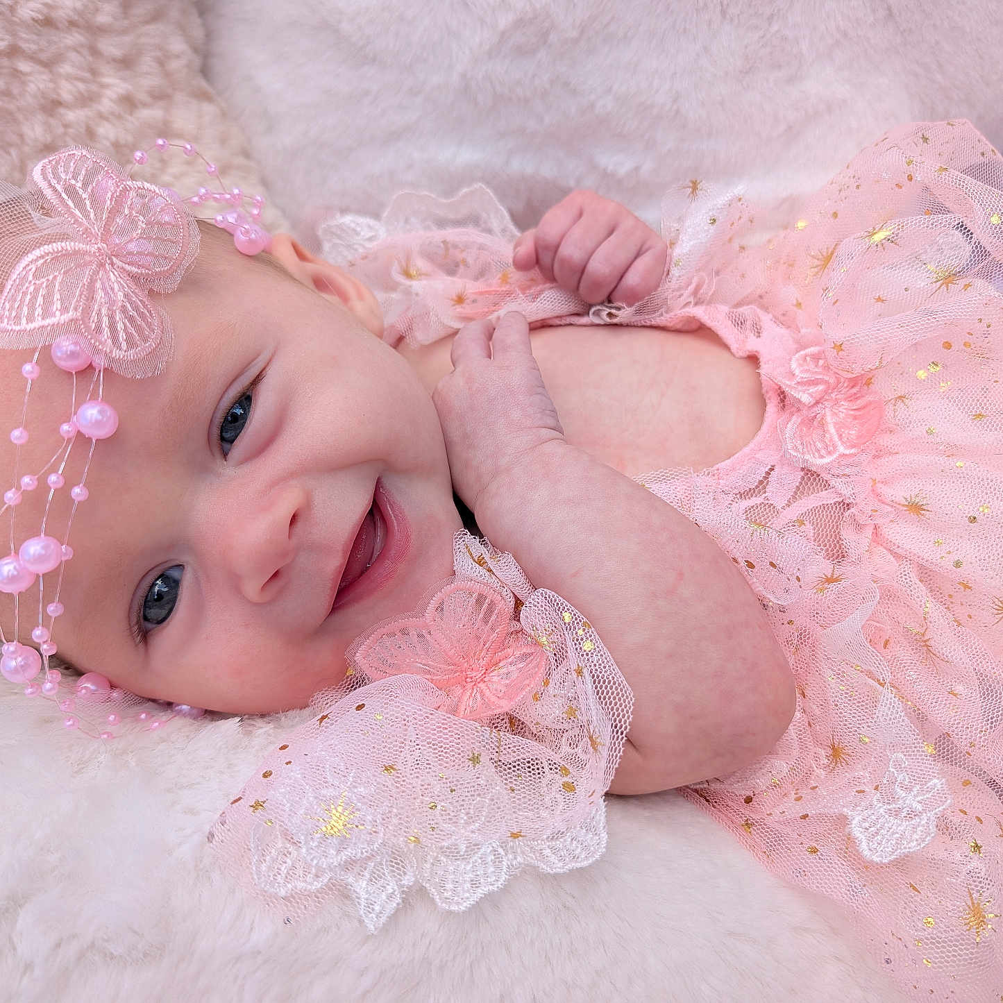 Bonnie joined the competition — help win amazing prizes! baby, infant, child, smiling, portrait, pink_dress, dress, headpiece, butterfly, sparkles, blanket, fluffy, lying_down, indoors, close_up, face, eyes, hands, fashion, happy