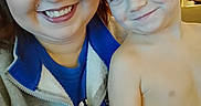 Damon is registered to the contest to win money with this photo: woman, child, smile, glasses, shirtless, indoor, portrait, happy, person, face, jacket, zip_up, blue_shirt, light_skin, short_hair, casual, family, closeup, hand, cozy