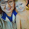 woman, child, smile, glasses, shirtless, indoor, portrait, happy, person, face, jacket, zip_up, blue_shirt, light_skin, short_hair, casual, family, closeup, hand, cozy