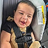 Massimo joined the competition — help win amazing prizes! baby, child, car_seat, seat_belt, smile, happy, plush_toy, clothing, black_shirt, overalls, infant, cute, secure, safety, car_interior, seat, closeup, portrait, young_child, child_safety