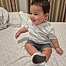 toddler, child, smiling, bed, bedding, curtains, indoors, clothing, shorts, hoodie, sneakers, fabric, pattern, person, furniture, home, cute, happy, seated, portrait
