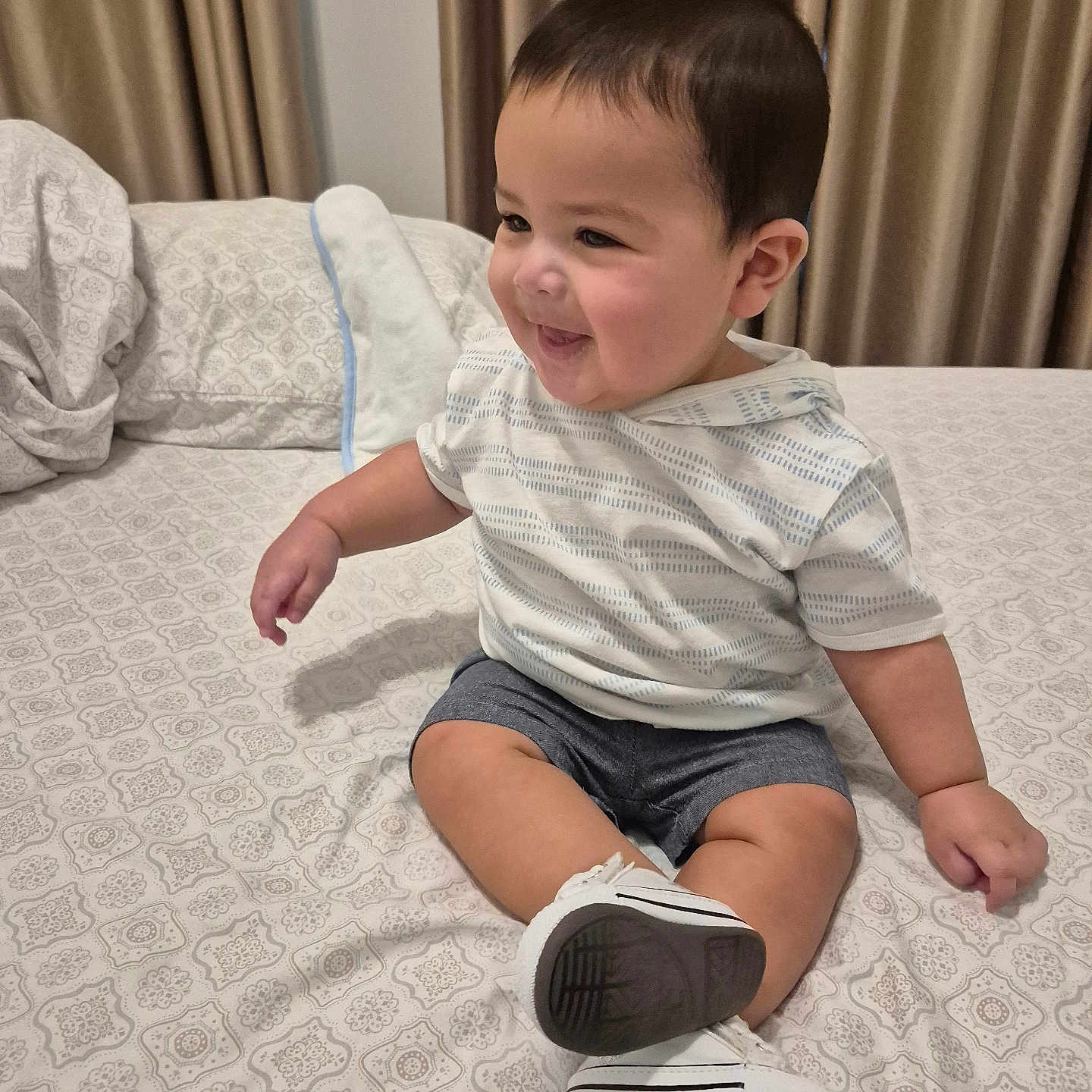 Massimo joined the competition — help win amazing prizes! toddler, child, smiling, bed, bedding, curtains, indoors, clothing, shorts, hoodie, sneakers, fabric, pattern, person, furniture, home, cute, happy, seated, portrait