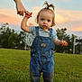 toddler, child, grass, overalls, denim, sunset, outdoor, person, hand, holding, walking, sky, nature, field, green, young_child, blue_eyes, cute, casual_clothing, hairstyle