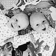 Elio Et Noa participe au concours pour gagner de l'argent avec cette photo : baby, infant, smiling, lying_down, toys, blanket, patterned_clothing, cute, playful, face, child, black_and_white, happy, indoors, two_babies, closeup, expression, young, adorable, peaceful
